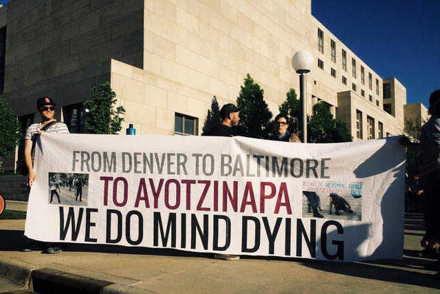 Protesters holding banner which reads 'From Denver to Baltimore to Ayotzinapa We Do Mind Dying'