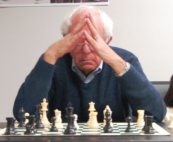 Senator Sanders sitting in front of a chess board.
